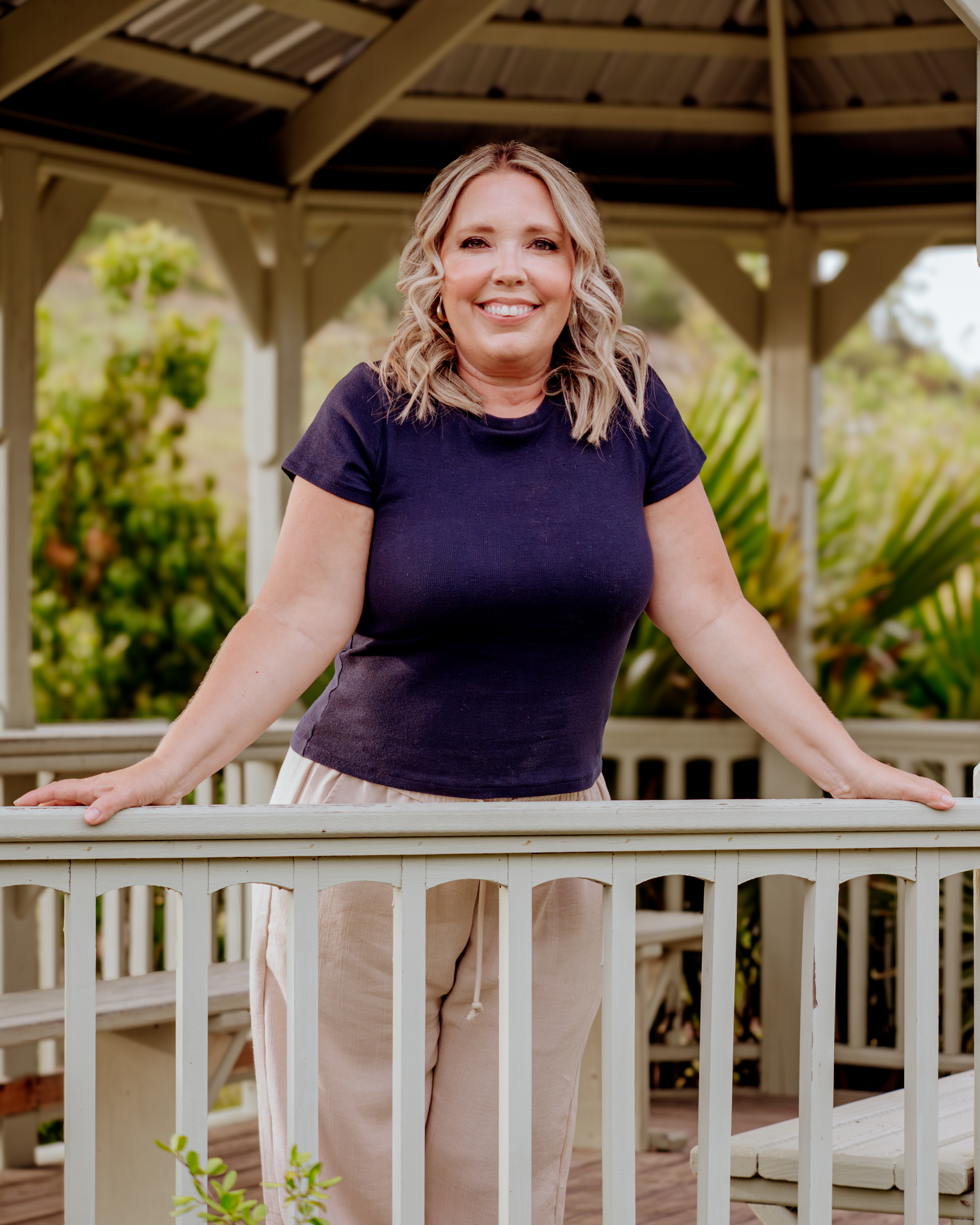Portrait of Sara Marranca, LCSW, smiling warmly outdoors in a garden gazebo.